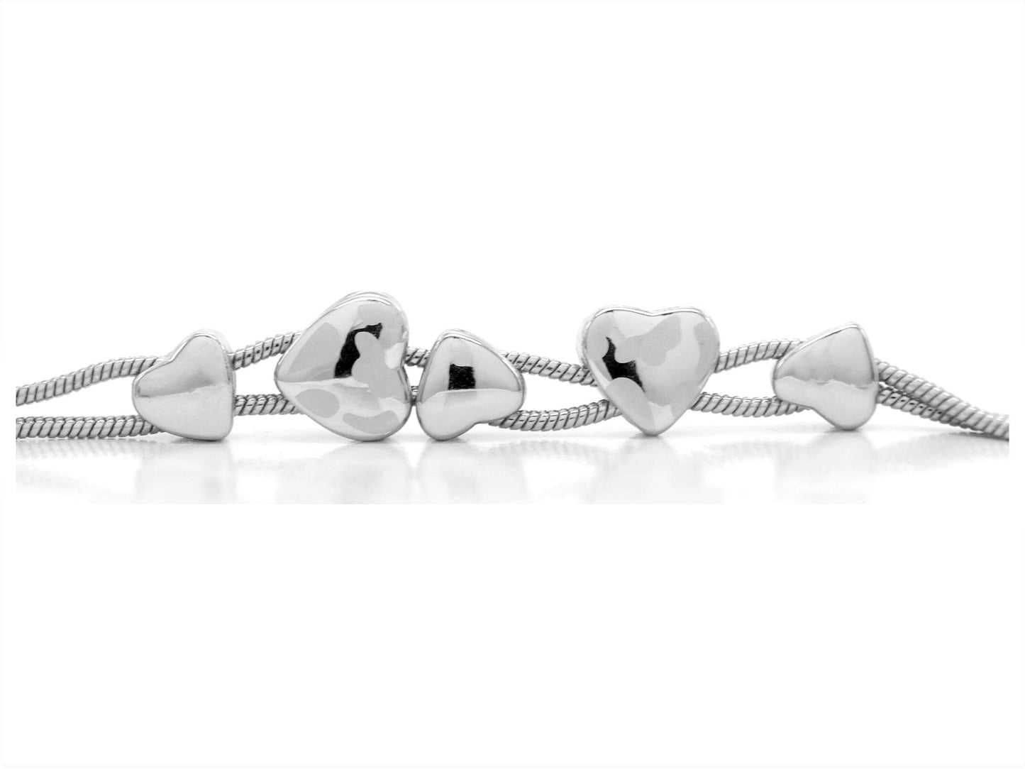 Silver heart-shaped beads on a white background