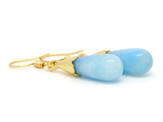 Gold earrings with blue stones on a white background