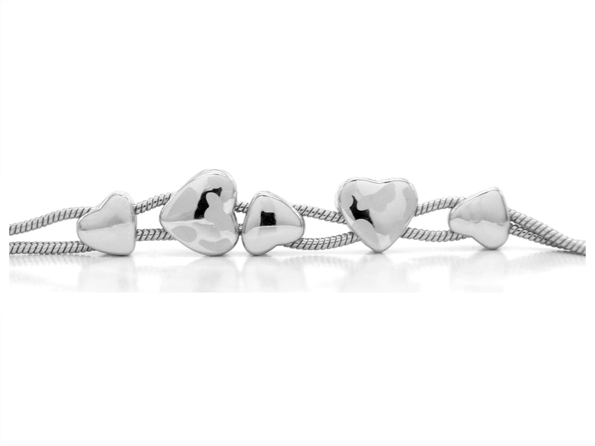 Silver heart-shaped beads on a white background