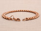 Rose gold bracelet on a beige fabric background