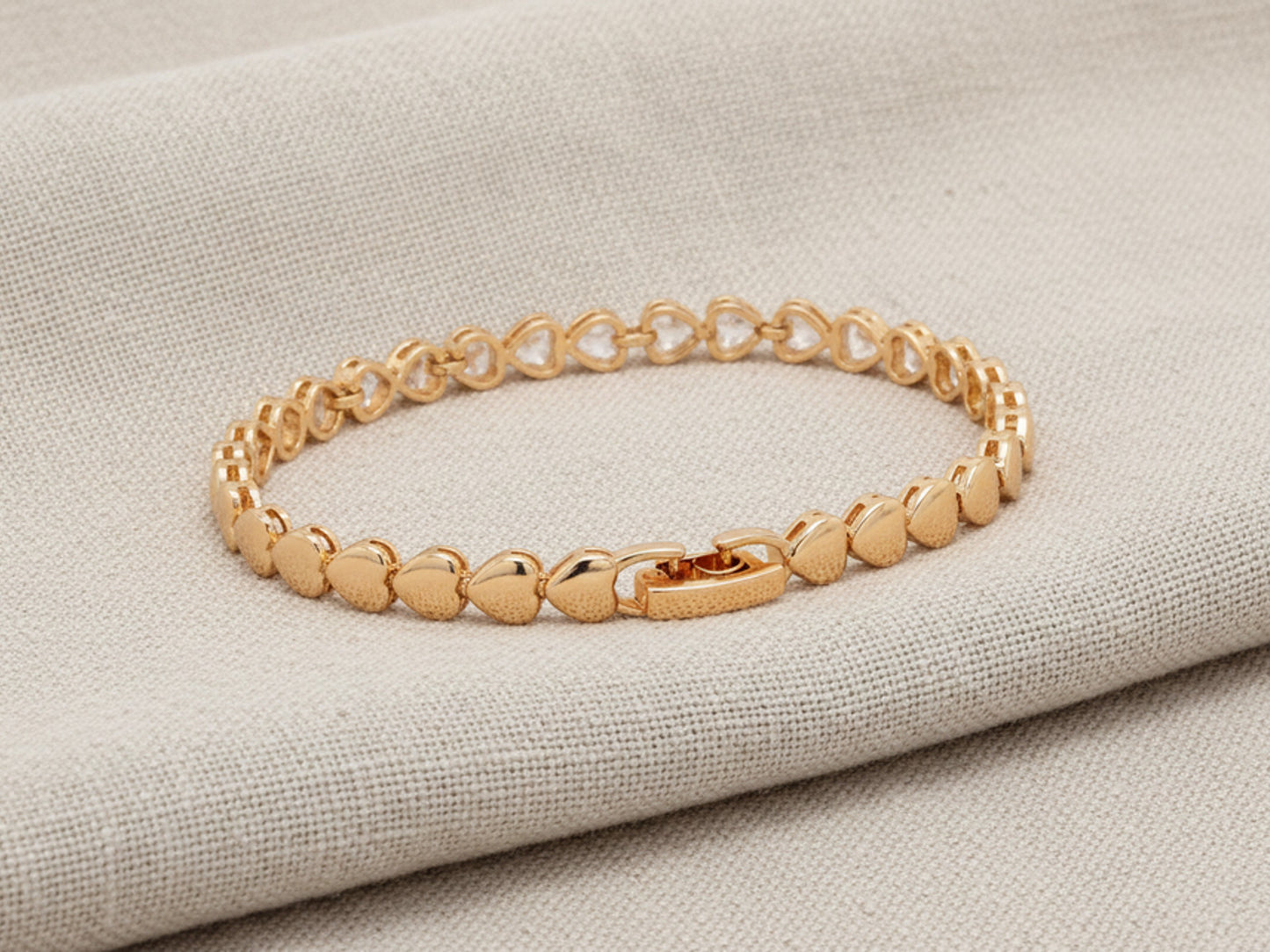 Gold bracelet on a textured beige surface