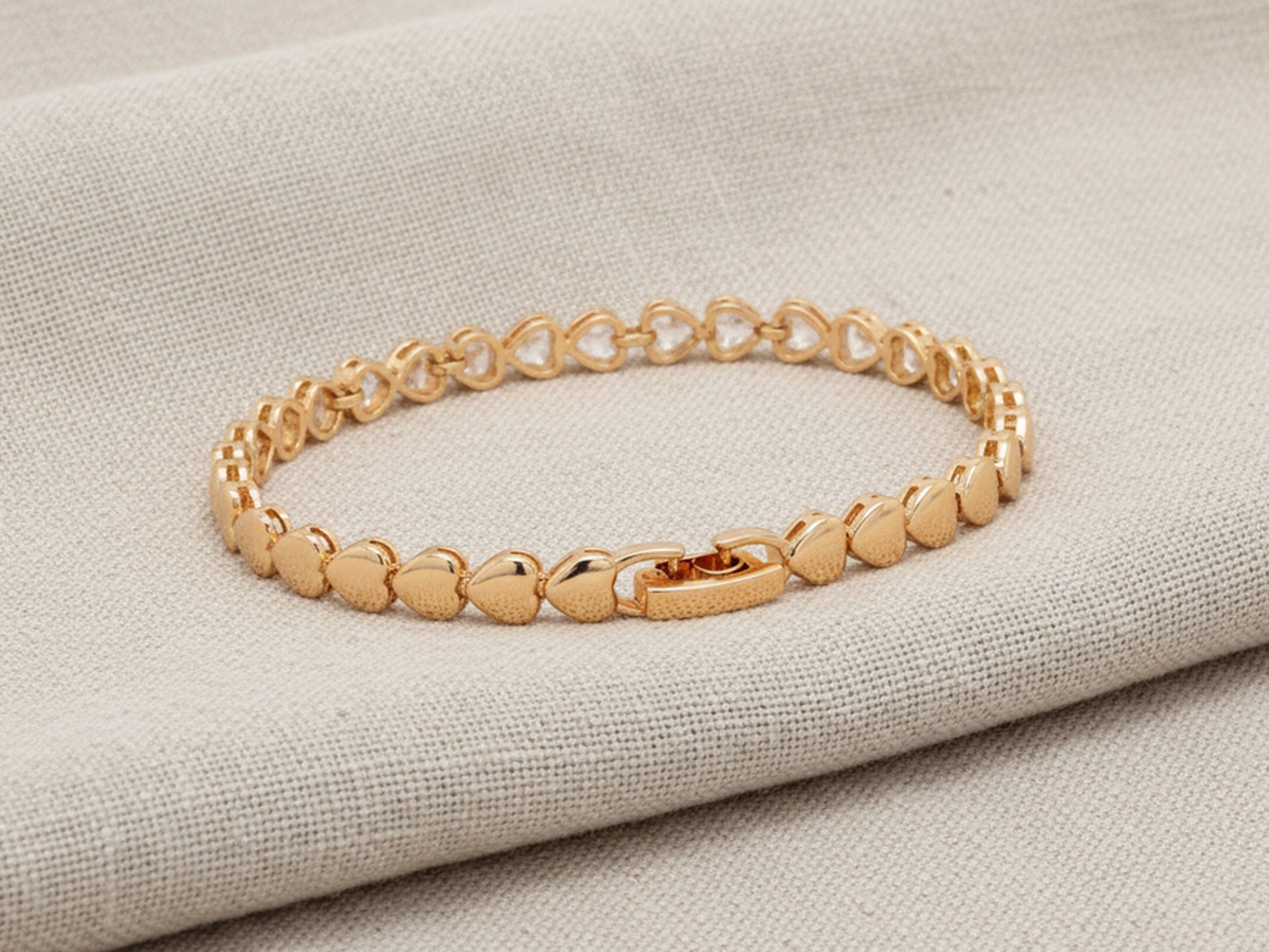 Gold bracelet on a textured beige surface