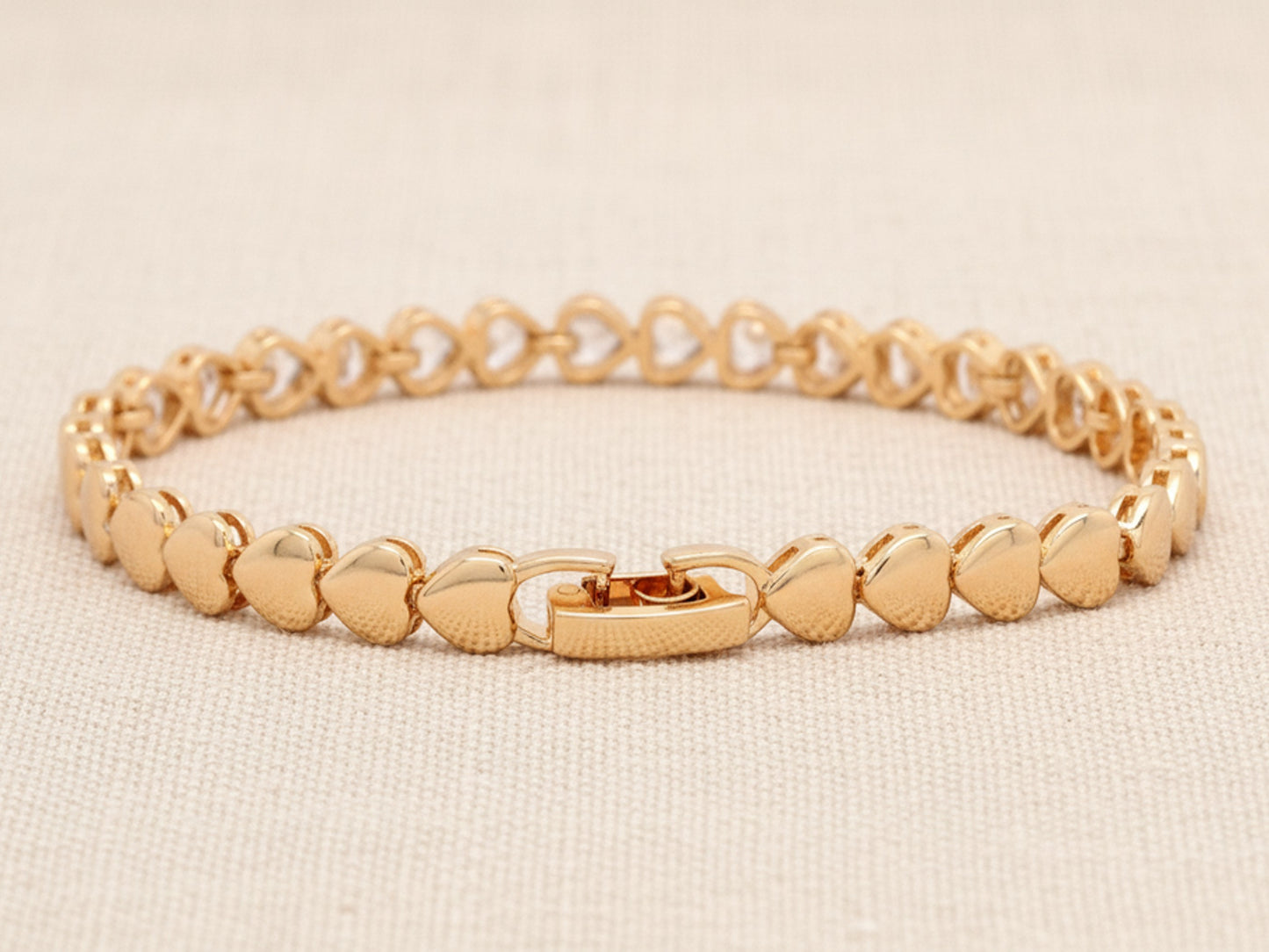 Gold bracelet on a beige background