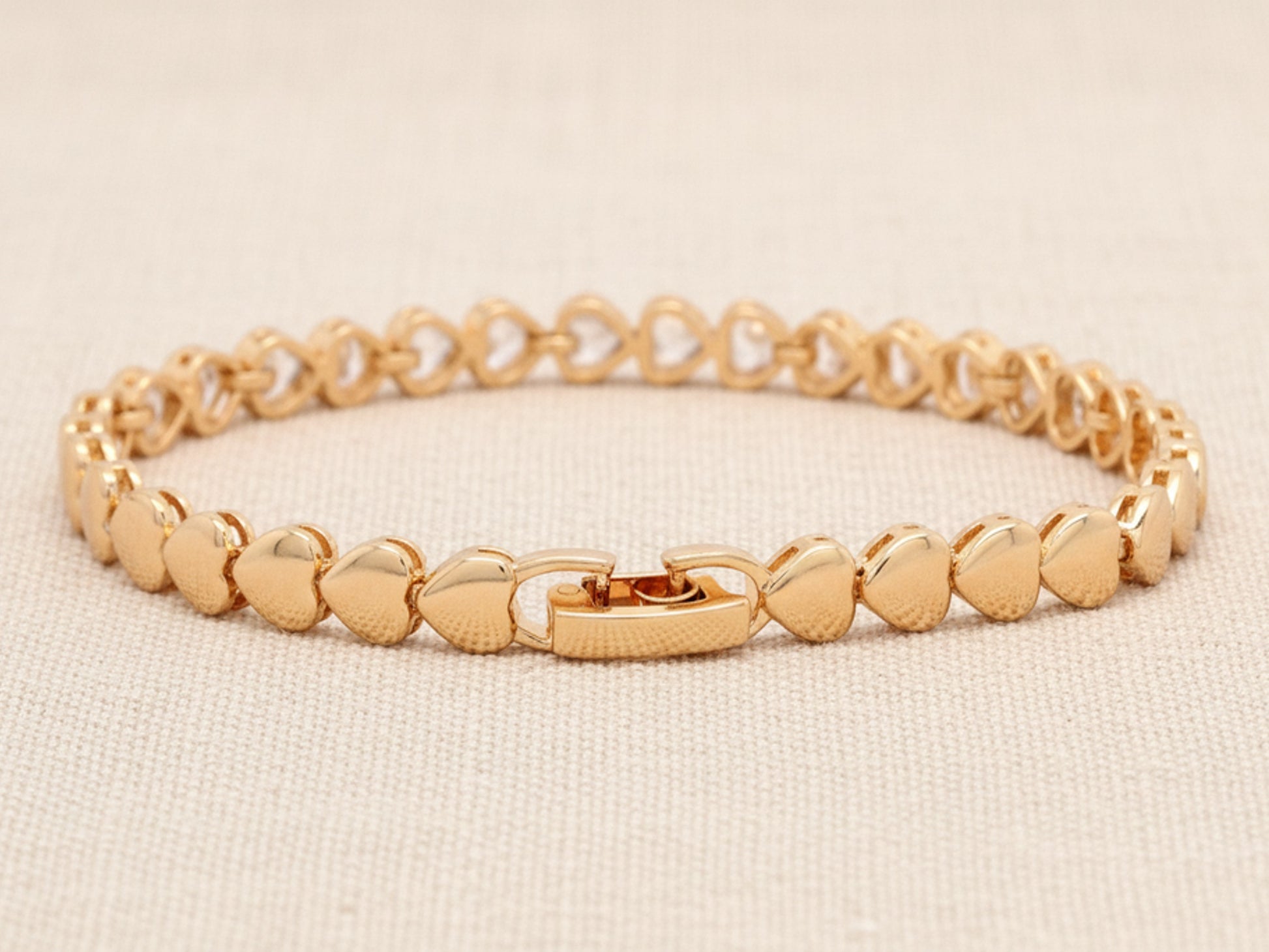 Gold bracelet on a beige background
