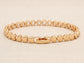 Gold bracelet on a beige background