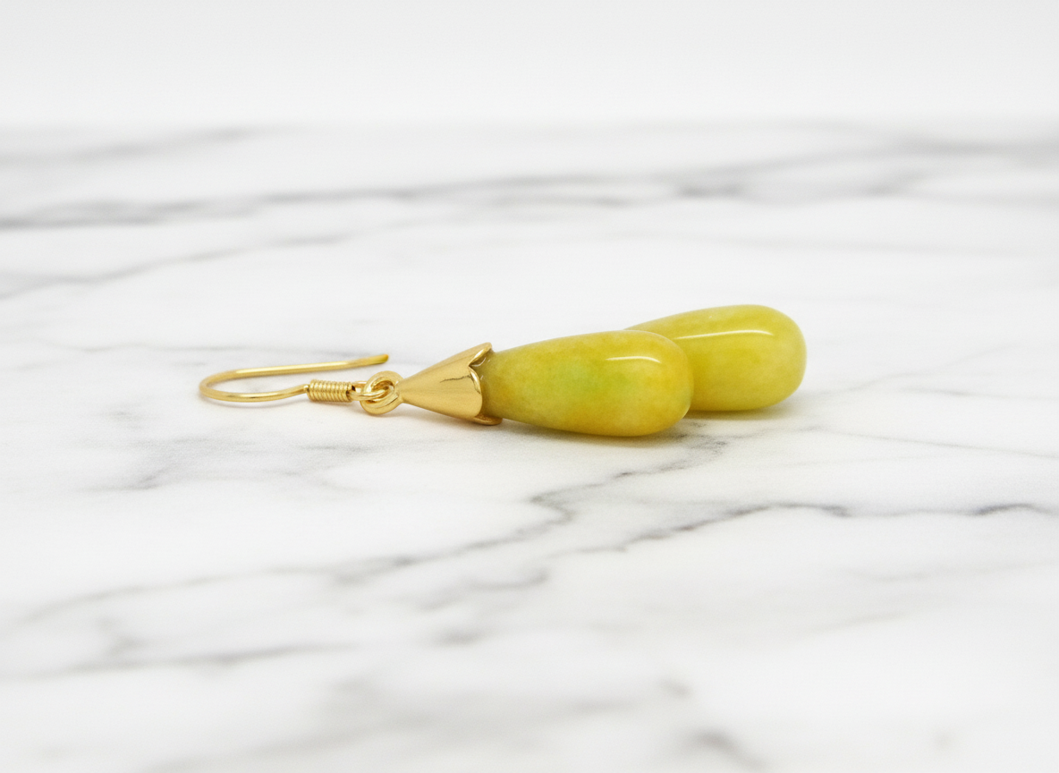 Yellow stone earring with gold hook on a white background
